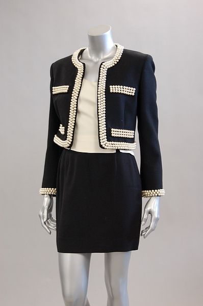 A Moschino pearl-edged suit, 1991: A Moschino pearl-edged suit, 1991, couture labelled, comprising: short, boxy jacket edged in large pearls, matching ivory crepe vest bodice and short wool skirt, size label GB10, US8, chest 96cm, 38in