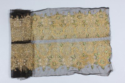 Two uncut beetle-wing adorned dress flounces, Indian,: Two uncut beetle-wing adorned dress flounces, Indian, circa 1890, the dark brown tulle ground couched in told threads, and adorned with insect wings, pearl and glass beads, each approx 25 by 172cm; to