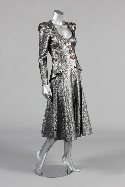 A Biba silver cloque evening suit, mid 1970s, with: A Biba silver cloque evening suit, mid 1970s, with printed art-nouveau label, the jacket with Edwardian celluloid buttons, flared skirt, chest 92cm, 36in, also with 3 of the original 4 buttons; togeth
