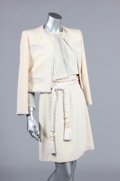 A Lancetti couture ivory ottoman wool cocktail suit,: A Lancetti couture ivory ottoman wool cocktail suit, 1980s, labelled, the boxy jacket and skirt adorned with white braid and embroidery, with thick rope-twist tasselled belt, matching chiffon blouse;