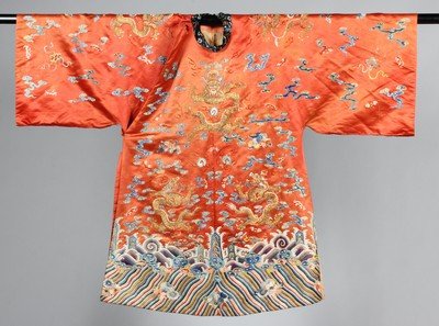 An embroidered orange satin dragon robe, mangao, circa: An embroidered orange satin dragon robe, mangao, circa 1900, couched and embroidered with eight gilt-thread dragons in pursuit of flaming pearls, floss silk embroidered hem