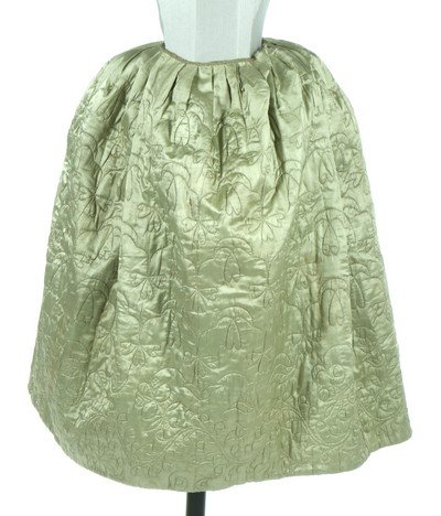 A quilted pale green satin petticoat, second half 18th: A quilted pale green satin petticoat, second half 18th century, with two pocket slits, overall design of shamrock repeats with tulips and other blooms to the hem, ribbon binding to waist, lined in gla