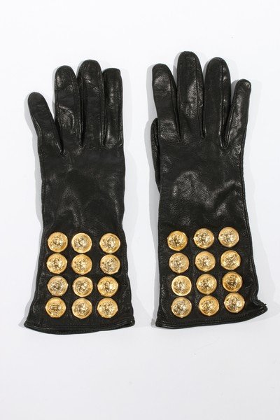 A pair of Gianni Versace black leather gloves, early: A pair of Gianni Versace black leather gloves, early 1990s, adorned with rows of gilt Medusa head buttons; together with a Versace cloth of gold jacket with Medusa buttons; and a Sophie Sitbon gold ve