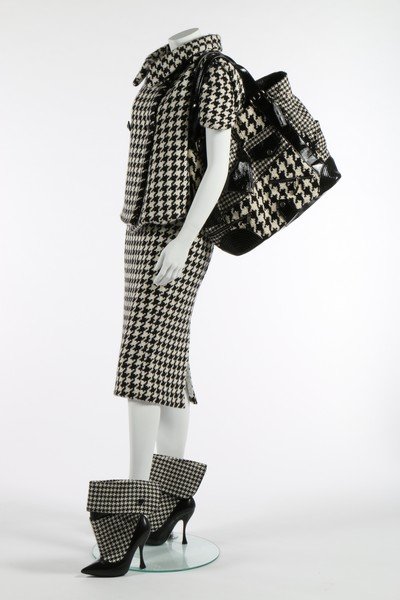 An Alexander McQueen hound's-tooth checked wool suit: An Alexander McQueen hound's-tooth checked wool suit and accessories, 'The Horn of Plenty' collection, Autumn-Winter, 2009-10, all labelled and size 44, comprising: double-breasted jacket with short w
