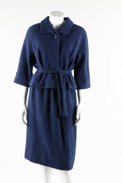 A Givenchy couture blue boucle wool suit, circa 1960.: A Givenchy couture blue boucle wool suit, circa 1960. Paris labelled and numbered 24938, comprising a buttoned jacket with tie belt to the front, with loose rear waist, matching skirt, chest approx 86