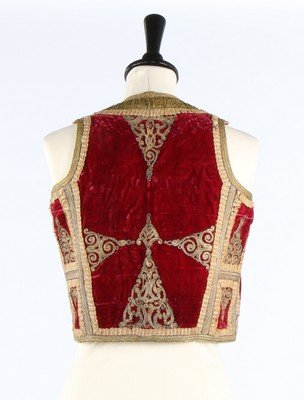 An embroidered crimson velvet bolero waistcoat,: An embroidered crimson velvet bolero waistcoat, probably Albanian, Ottoman, late 19th century. with gold thread toggle fastenings, couched gold embroidery and braid edgings; together with an elaborate