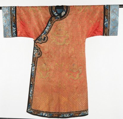 An embroidered orange satin dragon robe, jifu, early: An embroidered orange satin dragon robe, jifu, early 20th century. couched and embroidered overall in gold threads with coiling dragons against a foliate lattice ground, the black satin borders worked