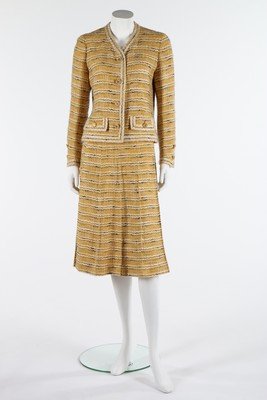 A Chanel couture yellow tweed suit, late 1960s-early: A Chanel couture yellow tweed suit, late 1960s-early 1970s, labelled to the skirt only and numbered 55601, the jacket lined in quilted yellow silk, gilt CC buttons, pleated A-line skirt, chest 97cm, 3