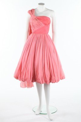 A pink draped chiffon couture cocktail dress,: A pink draped chiffon couture cocktail dress, attributed to Jean Desses, early 1950s, un-labelled, in shades of pink with gathered puff-ball hem, floating panel from one shoulder, integral corset and