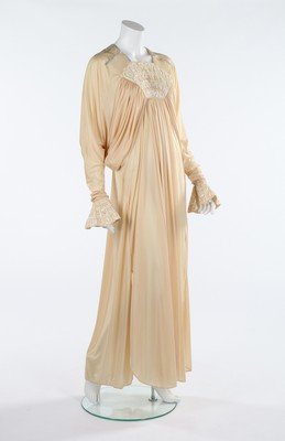 A Bill Gibb cream Quiana jersey evening dress,: A Bill Gibb cream Quiana jersey evening dress, Spring-Summer, 1973, labelled, with sequined shell-shaped panel to bodice, draped bat-wing sleeves and sequined flared cuffs, bust approx 86cm, 34in Char