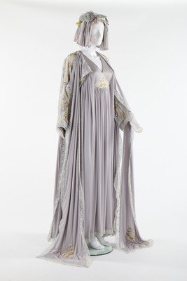 An opulent Bill Gibb grey Quiana jersey kaftan-like: An opulent Bill Gibb grey Quiana jersey kaftan-like 'Bee' dress, Autumn-Winter, 1973, labelled, the bodice embroidered and beaded with central bee motif, the voluminous bat-wing sleeves adorned with s