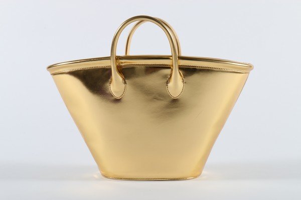 A Comme des Garcons bucket-shaped gold vinyl shopping: A Comme des Garcons bucket-shaped gold vinyl shopping bag, circa 2008, 53cm, 21in