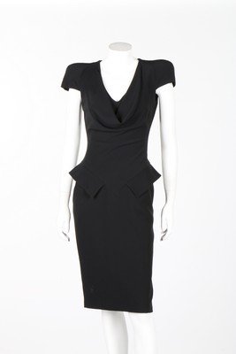 An Alexander McQueen black crepe drape-fronted dinner: An Alexander McQueen black crepe drape-fronted dinner dress, 2009, labelled and size 38, with accentuated padded shoulders, low cowl to neck, pointed panels over the hips, bust 86cm, 34in, waist 61cm,