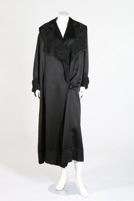A Peter Robinson black satin evening coat applied with: A Peter Robinson black satin evening coat applied with embroidered lace c.1918-20, together with a cream wool coat with soutache decoration; and a 1920s pink velvet evening cape (3)