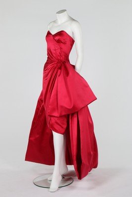 A Guy Laroche couture pink satin cocktail gown, 1980s,: A Guy Laroche couture pink satin cocktail gown, 1980s, Paris labelled, boned strapless bodice with cross-over pleating, large bow to one hip, short skirt and train, bust approx 81cm, 32in