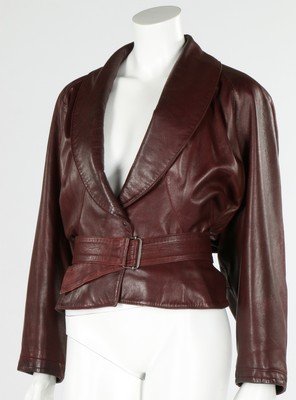 An Azzedine Alaia brown leather jacket, 1980s, labelled: An Azzedine Alaia brown leather jacket, 1980s, labelled and size 40, with pleated side panels, cut short at the back and long at the front, wrap around belt, chest approx 97cm, 38in