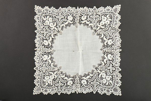 Queen Victoria's Honiton lace handkerchief, stockings: Queen Victoria's Honiton lace handkerchief, stockings and a damask napkin, mid-late 19th century, the lawn handkerchief with deep Honiton borders; the white cotton stockings knitted to the tops with l