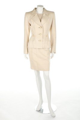 An Yves Saint Laurent couture ivory slubbed silk: An Yves Saint Laurent couture ivory slubbed silk cocktail suit, early 1980s, labelled and numbered 07041?, comprising jacket with large pearlised buttons, matching skirt with button detailing and sati