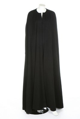 An Yves Saint Laurent black cashmere full length: An Yves Saint Laurent black cashmere full length evening cape, 1980s, Paris labelled; together with a nude chiffon and black Chantilly lace Bill Blass couture evening gown, un-labelled, bust 92cm, 36i