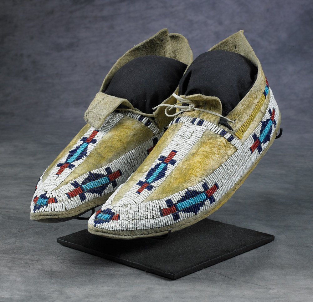 Arapaho Beaded Moccasins: 10" total length, geometric designs in red, light and dark blue and white on yellow stained native tanned hide. Fine condition, c 1890