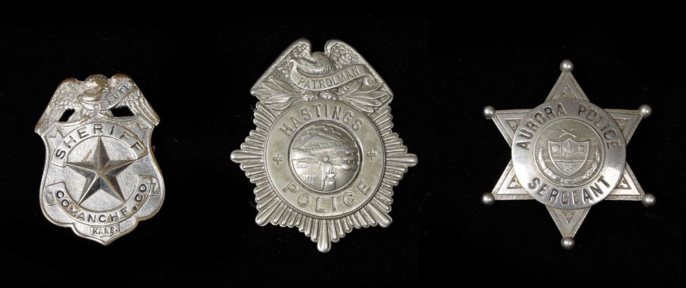 Three Badges: a) Patrolman / HASTINGS, Nebraska Police, 3" x 2 1/2", stamped C D Reese, 57 Warren St, New York; b) Deputy Sheriff / Comanche County, Kansas, 2 1/4" x 1 3/4"; c) Aurora Police Sergeant, Aurora, Color