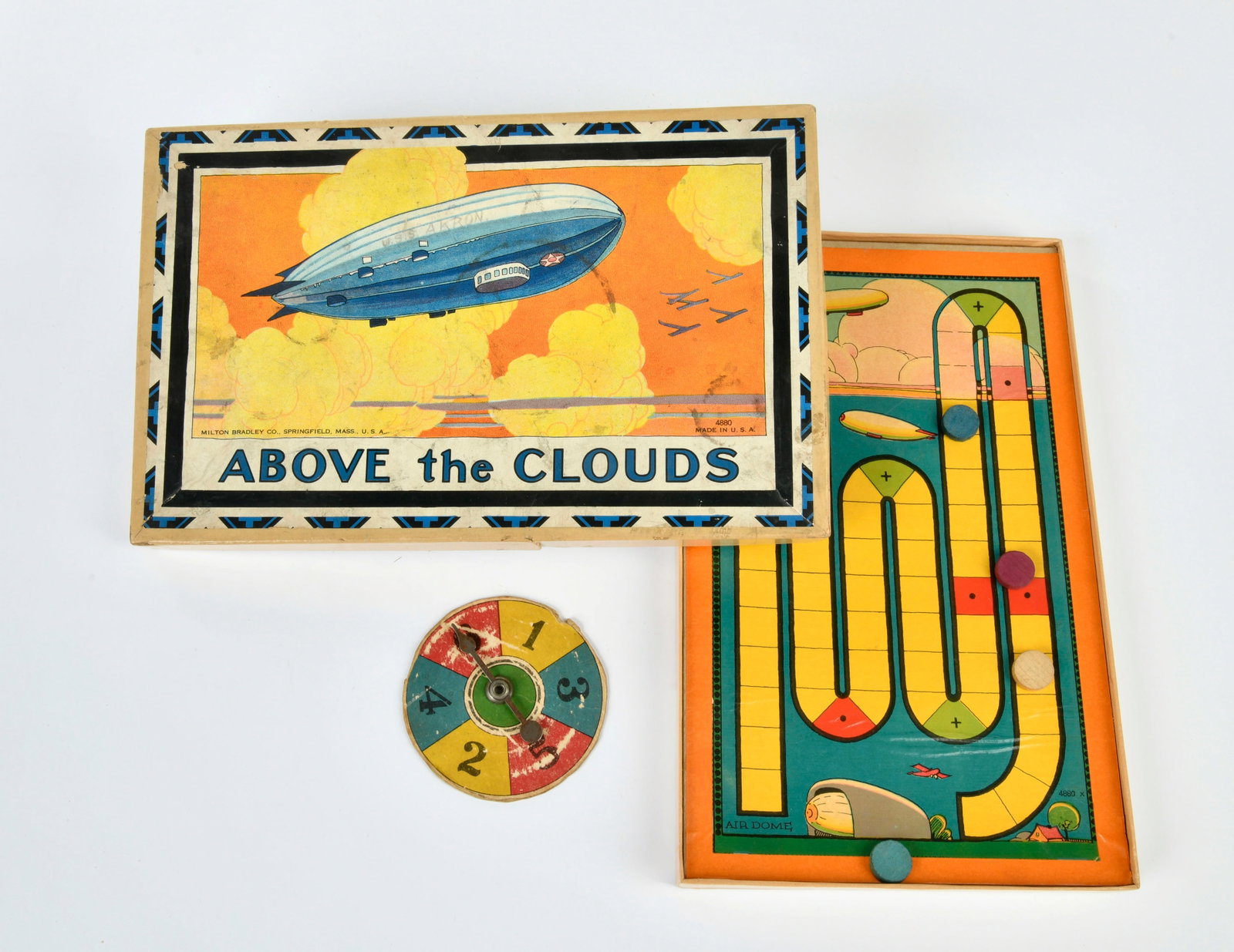 Milton Bradley Co., Zeppelin-Spiel "Above the Clouds": Milton Bradley Co., Zeppelin game "Above the Clouds", USA, 28 x 17,5 cm, complete with instruction manual, with turntable instaed of dices, traces of age and use, otherwise very nice