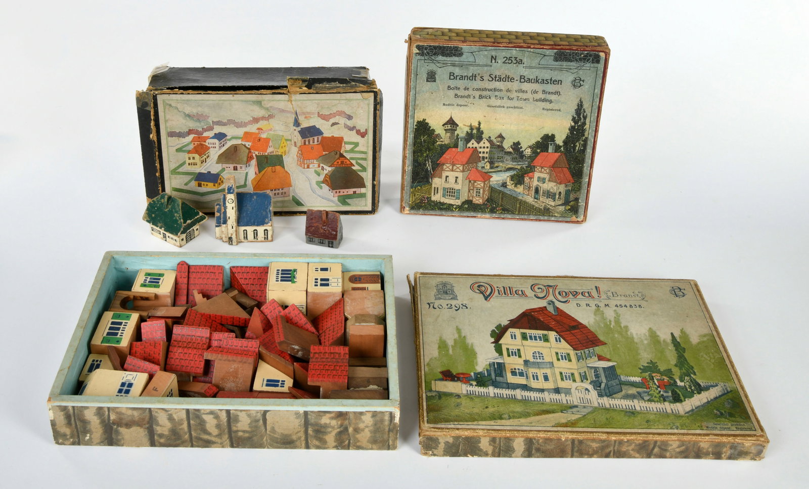 Carl Brandt junior (Gossnitz) u.a., 3 Baukasten: Carl Brandt junior (Gossnitz) a.o., 3 house construction sets: darunter Villa Nova No. 298, Stadte Baukasten 253a, Germany 1905-1911, wood, 19-26 cm, boxes (damaged), with 2 instruction manuals, C 2-3