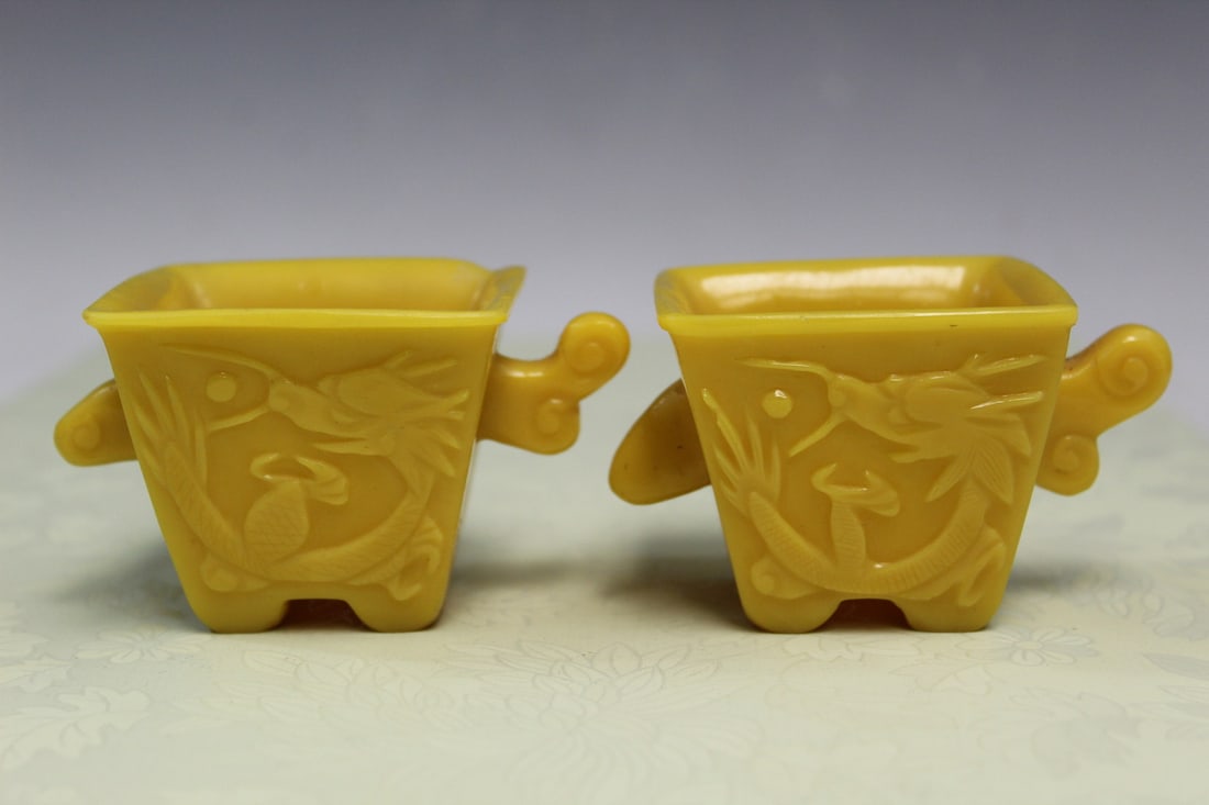 Pair of Chinese Yellow Glass Dragon Cups.: Pair of Chinese Yellow Glass Dragon Cups.. L 9 cm. As Is.