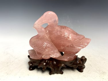 Chinese carved rose quartz statue of a duck on wood stand.