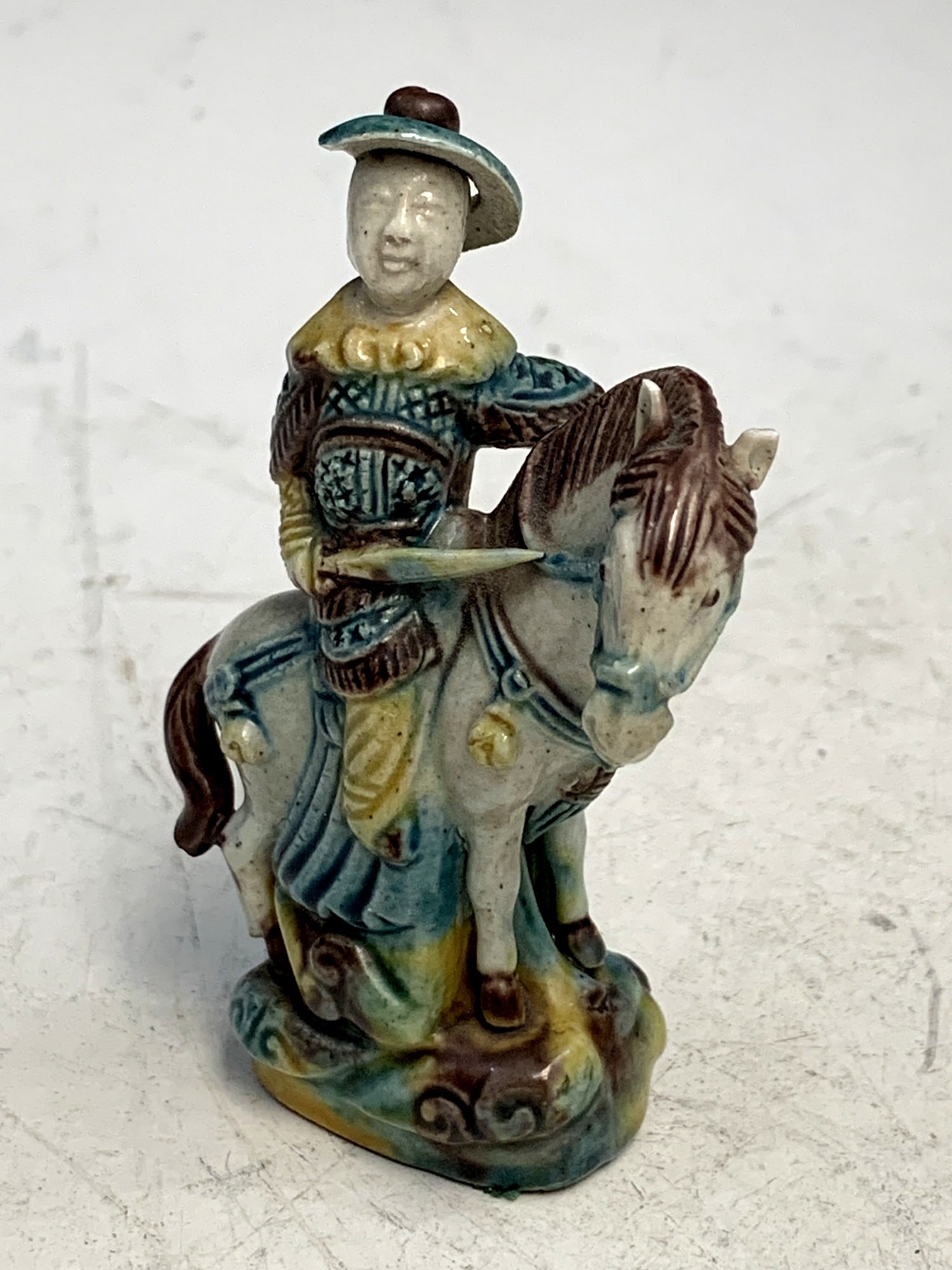 Small pottery figure of a man riding on a horse. (1 of 4)