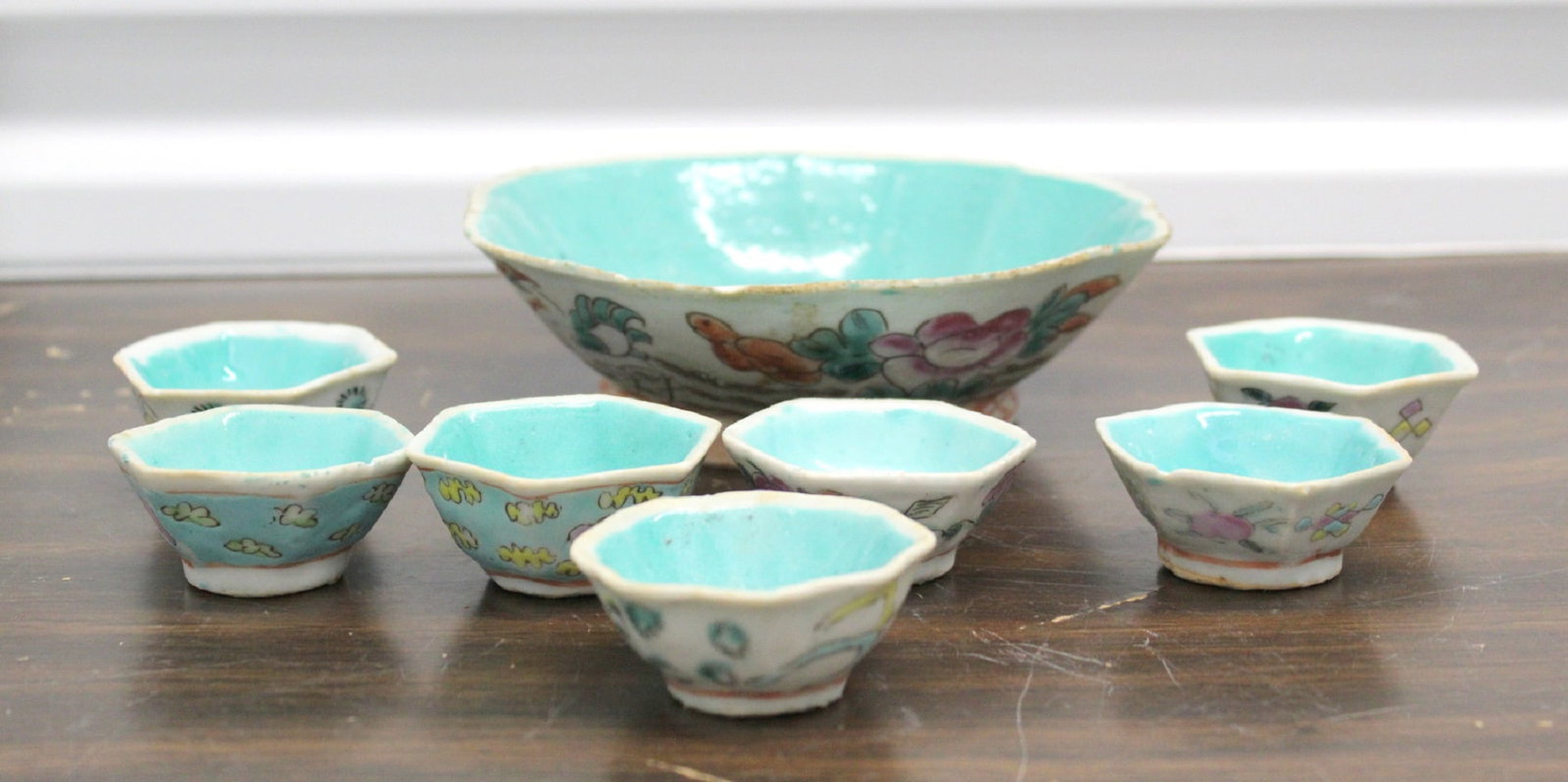 A Chinese famille rose porcelain bowl and seven cups: A Chinese famille rose porcelain bowl and seven cups. Bowl diam 6.5". Height 2". Cup diam 2 1/4".