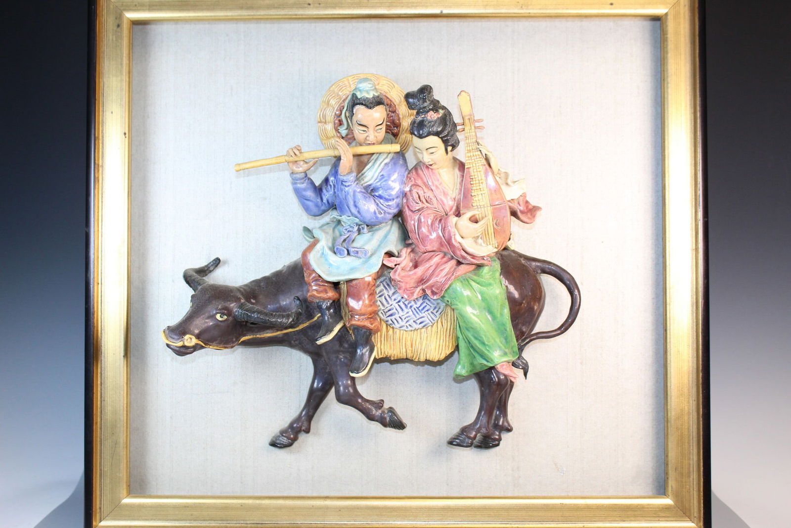 Large Chinese Framed Pottery Figure of a Chinese Couple Riding a Buffalo: Large Chinese Framed Pottery Figure of a Chinese Couple Riding a Buffalo. Figure 14x13x4". Frame 19.5x21.5".