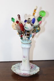 Asian hat pins on porcelain Holder