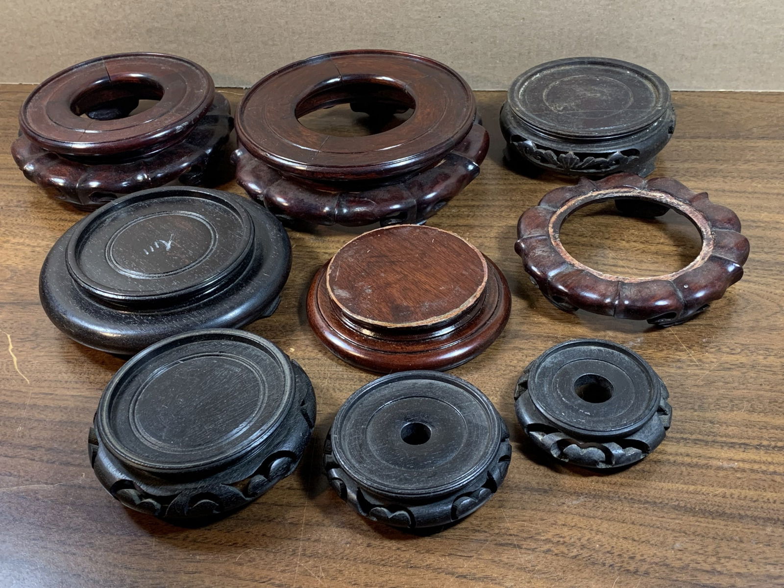 Group of nine circular wood stands: Group of nine circular wood stands. Largest diameter 6.25". Smallest diameter 2.5".