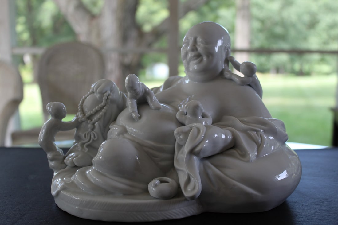 Chinese Blanc de Chine porcelain statue of a laughing buddha: Chinese Blanc de Chine porcelain statue of a laughing buddha. H 7". L 10". W 6.25".