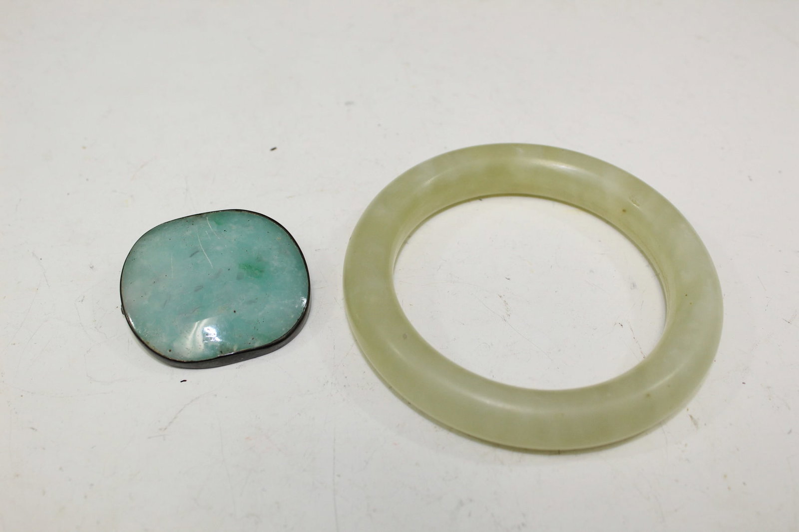 Jade bangle and brooch.: Jade bangle and brooch. Outside bangle diameter 4". Inside diameter 2.5". Brooch size 2" X 1 3/4".