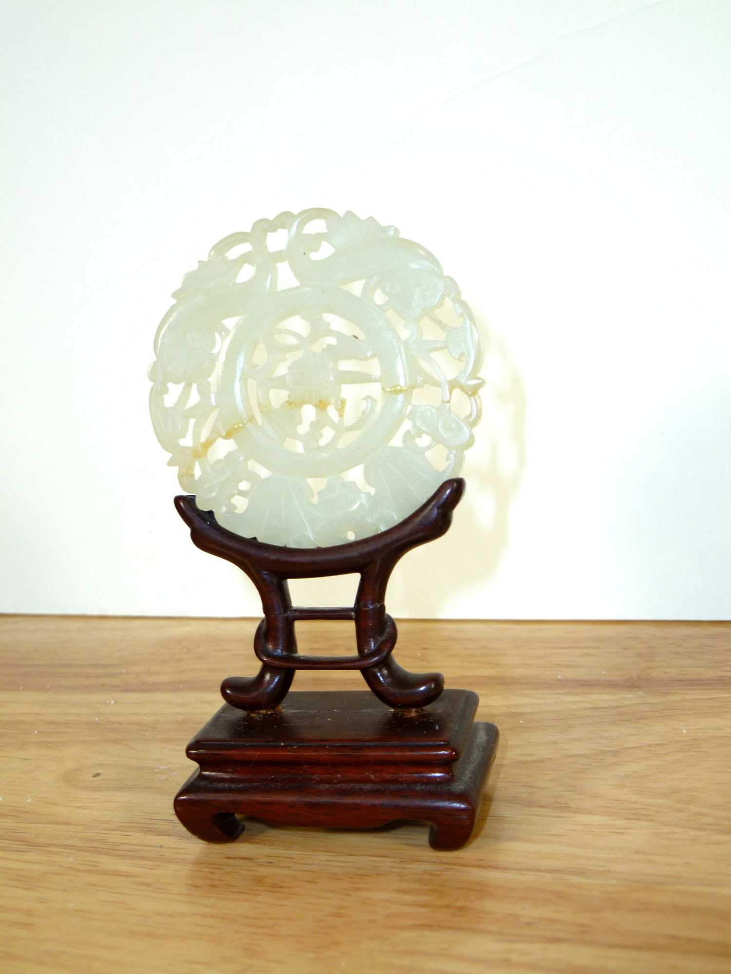 Chinese Carved White Jade Pendant on Wood Stand: Chinese Carved White Jade Pendant on Wood Stand. Diam 2.25". As Is.