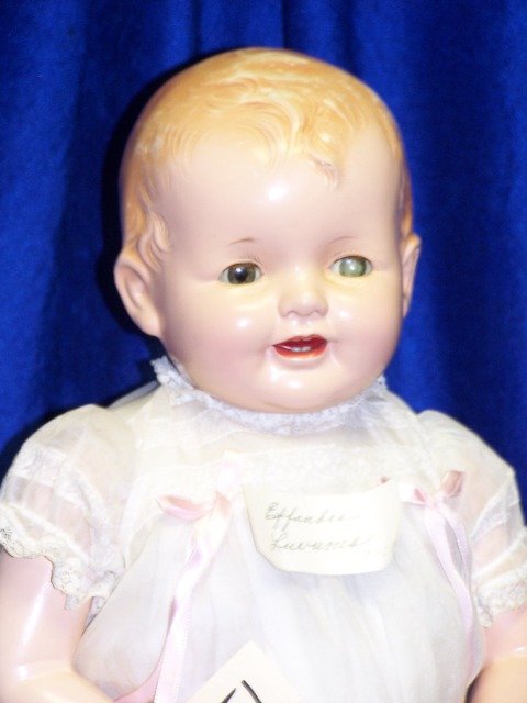 EFFANBEE. LOVUMS. 1928.: 28" SOFT BODY, COMP ARMS,LEGS. OPEN MOUTH WITH TWO ROWS TEETH. MOLDED CURLY HAIR. CRAZING UNDER LEFT EYE. NICE COSTUME. ORIGINAL CHARM BRACELET. VERY GOOD CONDITION.