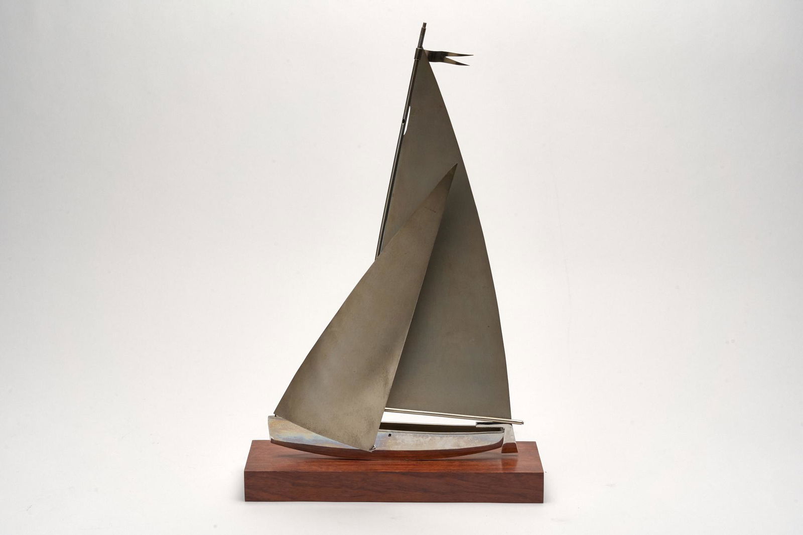 Brass & Wood Modernist Sailtboat Sculpture: A finely crafted sculpture of a sailboat in a modernist style on a wood base. 17" x 10.5" x 3"