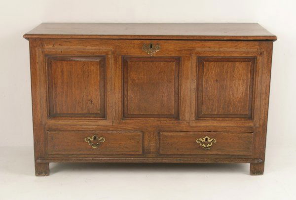 An oak mule chest, mid-18th century and later, th: An oak mule chest, mid-18th century and later, the two-planked hinge lid over three fielded rectangular panels (panel surrounds to the two side panels later cut into cabinet doors and then re-affixed)