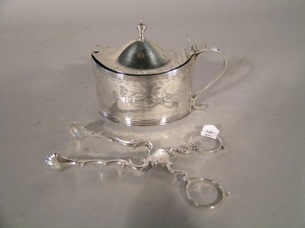 A silver mustard with hinged cover Frances Purton: A silver mustard with hinged cover Frances Purton and Thomas Johnson London 1793, of typical oval form with engraved flowers and garlands and associated blue glass liner 7cm high and a pair of George