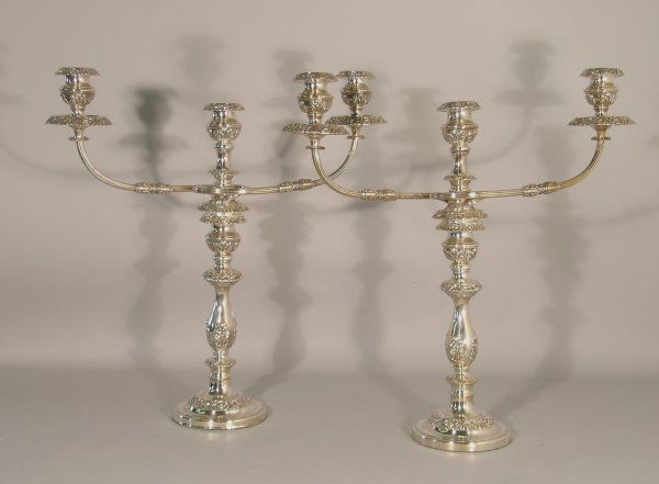 A pair of silver plated candelabra, 20th century, e: A pair of silver plated candelabra, 20th century, each of baluster form and heavily embossed with stylised flowers and foliage, the central sconce issuing two sinuous branches (detachable to form cand