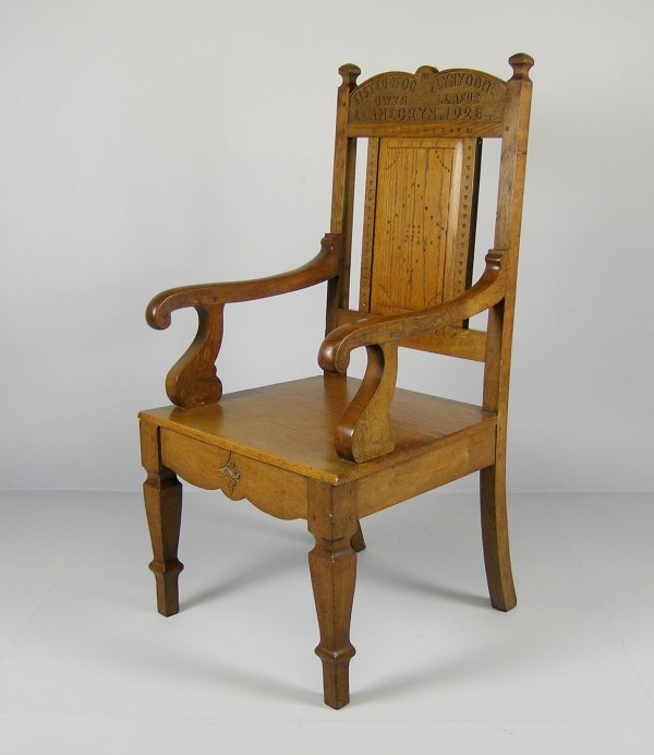 An Eisteddfod arm chair, oak, the arched top rail