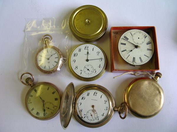 A box containing two pocket watch movements, thre