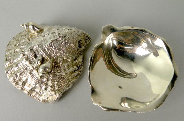 A matched pair of silver oyster salts, Richard Co: A matched pair of silver oyster salts, Richard Comyns London 1961 and 1973, each naturalistically modelled as an oyster shell, with plain polished interior and all raised on two further shell feet, 8c