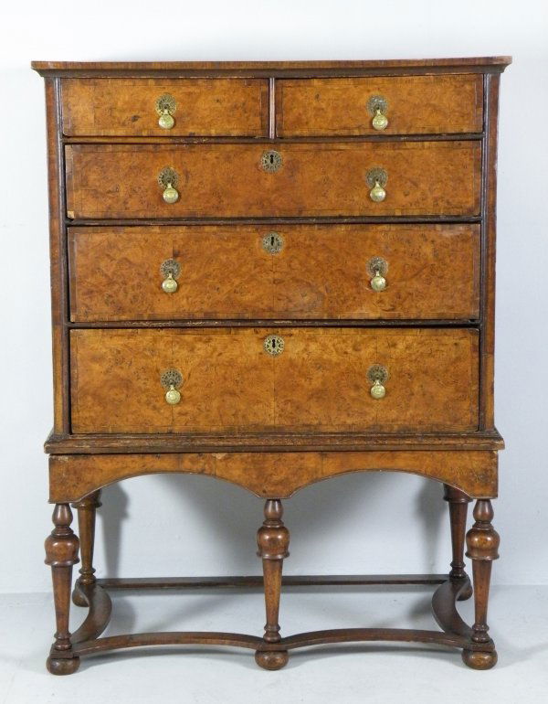 A walnut chest on stand, 18th century and later,: A walnut chest on stand, 18th century and later, the crossbanded rectangular top over two short and three long graduated drawers, fitted with replacement brass drop handles on a later stand with doubl