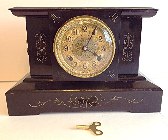 Antique Working New Haven Mantel Clock in Metal Case: Antique New Haven mantel clock in metal case, in working condition, strikes each half-hour and hour on an elegant sounding cathedral gong. Pendulum and key are included. Dimensions: 10"H x 14 1/2"W x 