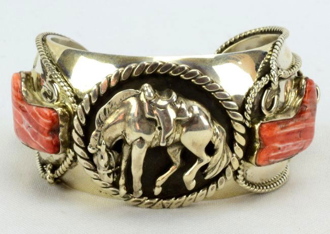 Russell Sam 3-D Bucking Bronc w/Spiny Oyster Bracelet: Measures 1.5 inches wide. This Bracelet has it all. The center has a Bucking Bronc in a 3-D style with a flat rope frame. The side pieces are Spiny Oyster pieces cut in the shape of boots complete wit