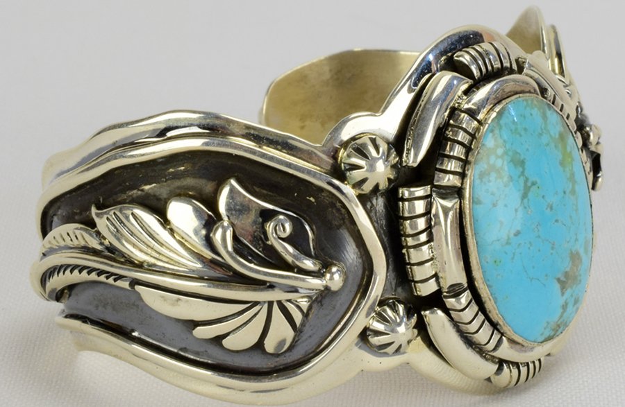 Jason B. Masterpiece Turquoise Overlay Bracelet: A substantial piece that measures 1.5 inches wide. It has an oval Natural Turquoise stone in the center and a very unique band. The Oval Turquoise stone has a nice traditional frame and the sides of t