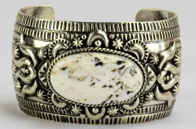 Marcella James Masterpiece White Buffalo Turq. Bracelet: Measures 1 5/8 inch wide with a completely hand stamped band. The bracelet has Repousse Applied to the top with a Natural White Buffalo Turquoise Stone. The stone is set East to West and is 1.5 inches